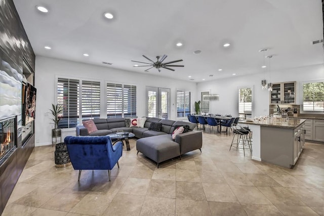 living room with ceiling fan, sink, and a fireplace