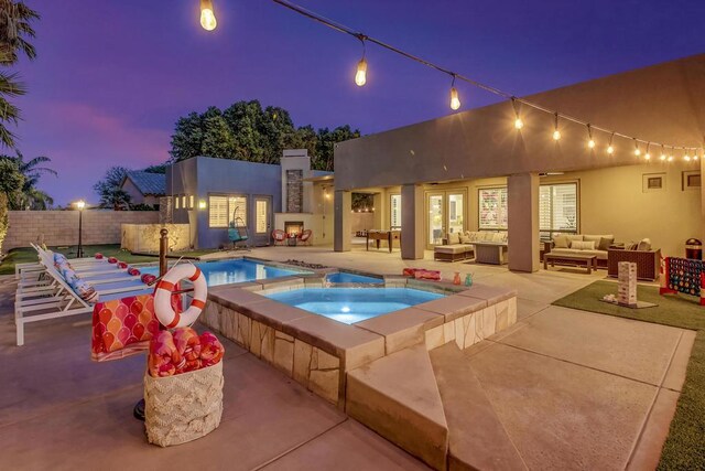 pool at dusk featuring an outdoor hangout area, a patio, and an in ground hot tub