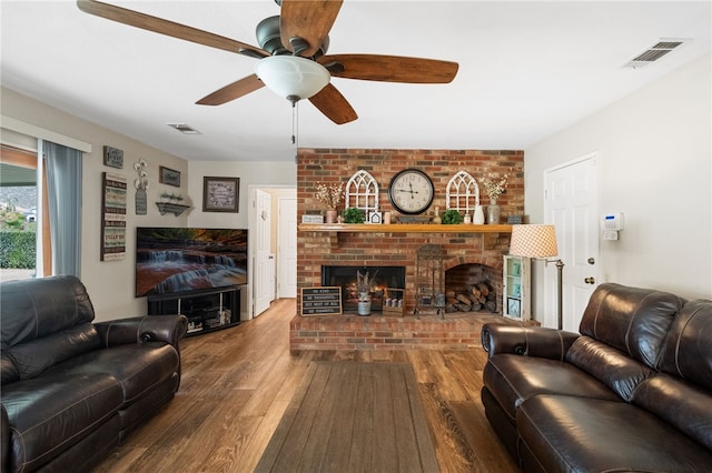 living room featuring ceiling fan, a fireplace, and hardwood / wood-style floors