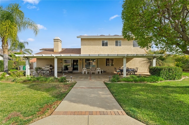 rear view of house with exterior kitchen, a patio area, and a lawn