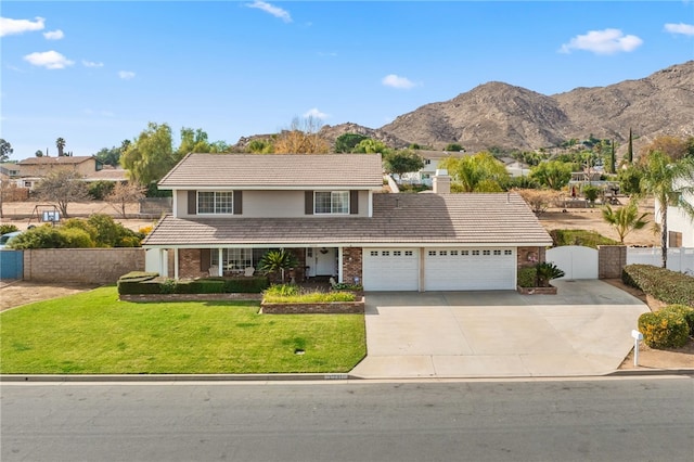 front facade featuring a front yard, a garage, and a mountain view