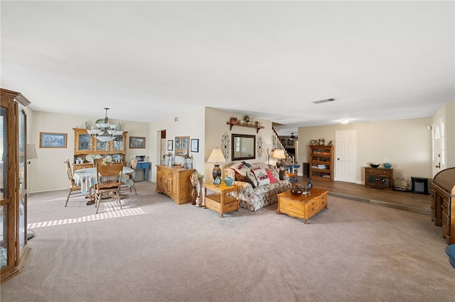 living room featuring light colored carpet and a notable chandelier