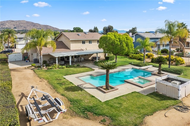 view of pool with a mountain view, central AC unit, a patio area, a yard, and an in ground hot tub