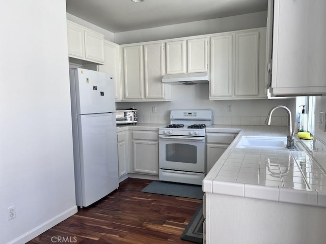 kitchen with sink, white appliances, tile counters, white cabinets, and dark hardwood / wood-style flooring