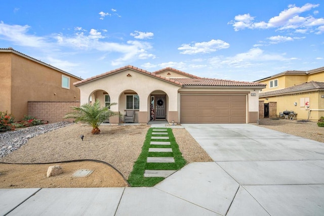 mediterranean / spanish home featuring a garage and a porch