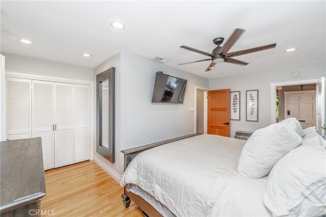 bedroom with ceiling fan, wood-type flooring, and a closet