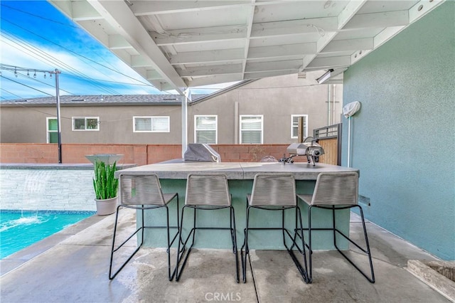 view of patio / terrace featuring exterior bar, a pool, and area for grilling