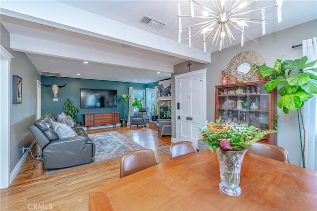 dining area with an inviting chandelier, beam ceiling, and hardwood / wood-style flooring