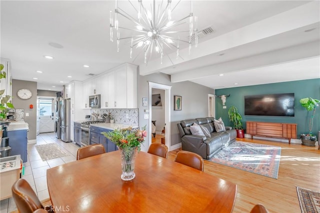 dining space featuring light tile patterned flooring and a chandelier