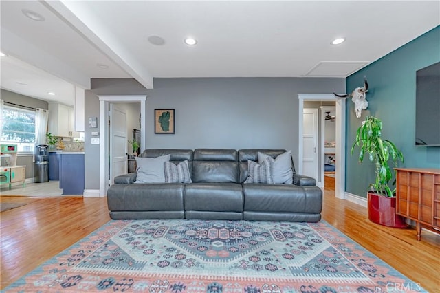 living room featuring light hardwood / wood-style floors and beam ceiling