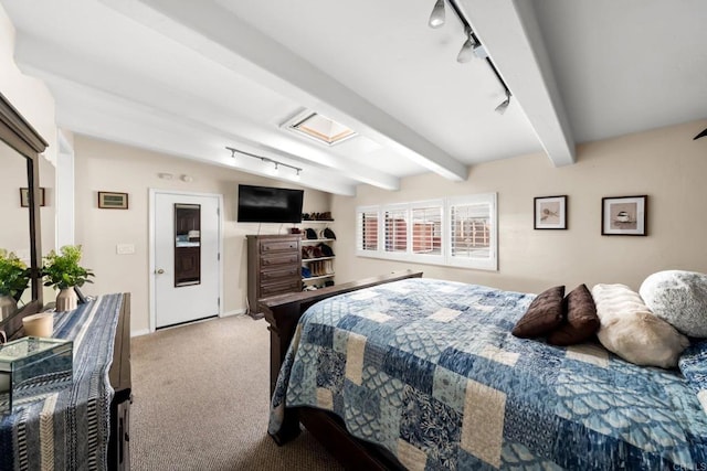 carpeted bedroom featuring rail lighting and lofted ceiling with beams