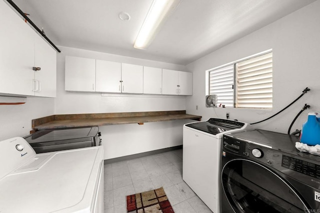 clothes washing area featuring washer and clothes dryer and cabinets