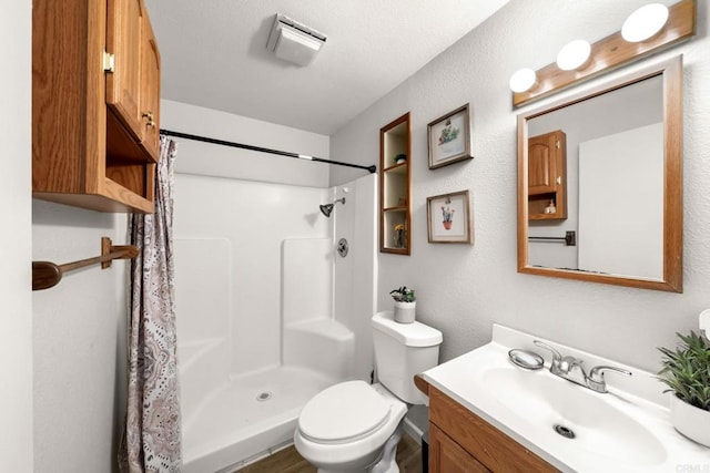 bathroom with toilet, vanity, and a shower with curtain