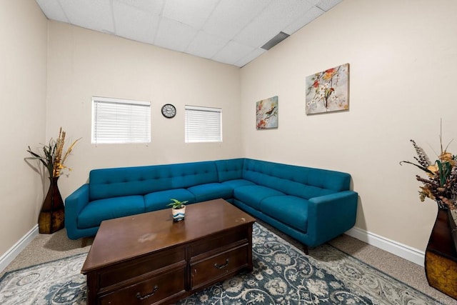 living room featuring a paneled ceiling and carpet flooring