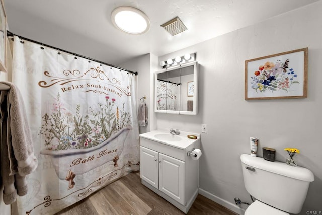 bathroom featuring toilet, vanity, walk in shower, and hardwood / wood-style floors