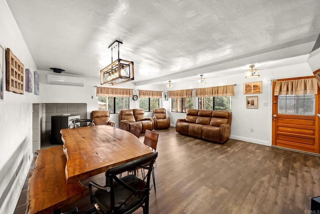 dining room with dark hardwood / wood-style flooring, a healthy amount of sunlight, a chandelier, and a wall mounted air conditioner