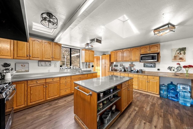 kitchen featuring appliances with stainless steel finishes, a kitchen island, dark hardwood / wood-style flooring, ventilation hood, and a wall mounted air conditioner