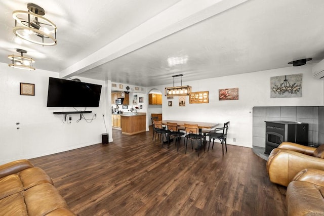 living room with ceiling fan, beam ceiling, dark hardwood / wood-style floors, and a wall mounted air conditioner