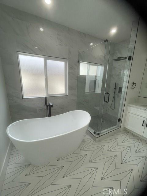 bathroom featuring separate shower and tub and vanity