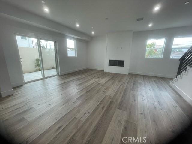 unfurnished living room featuring a healthy amount of sunlight and light wood-type flooring