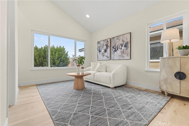 living area with vaulted ceiling and hardwood / wood-style floors