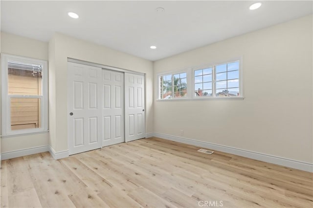 unfurnished bedroom featuring a closet and light hardwood / wood-style flooring