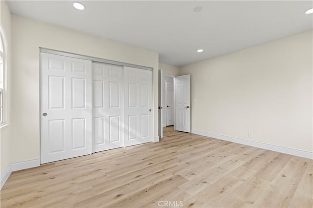 unfurnished bedroom with a closet and light hardwood / wood-style flooring