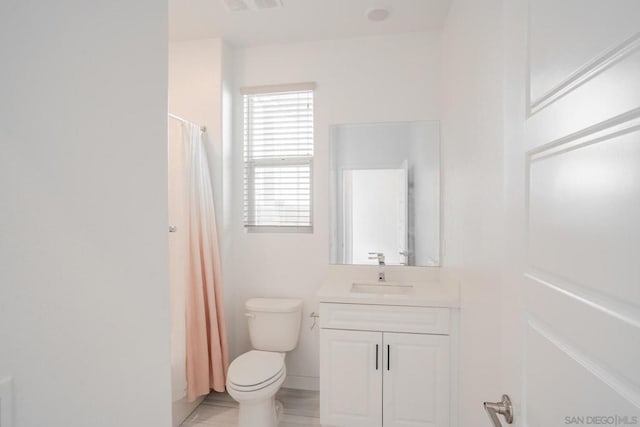 bathroom with toilet, vanity, and a shower with shower curtain