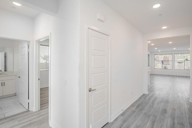 hall with light hardwood / wood-style floors and sink