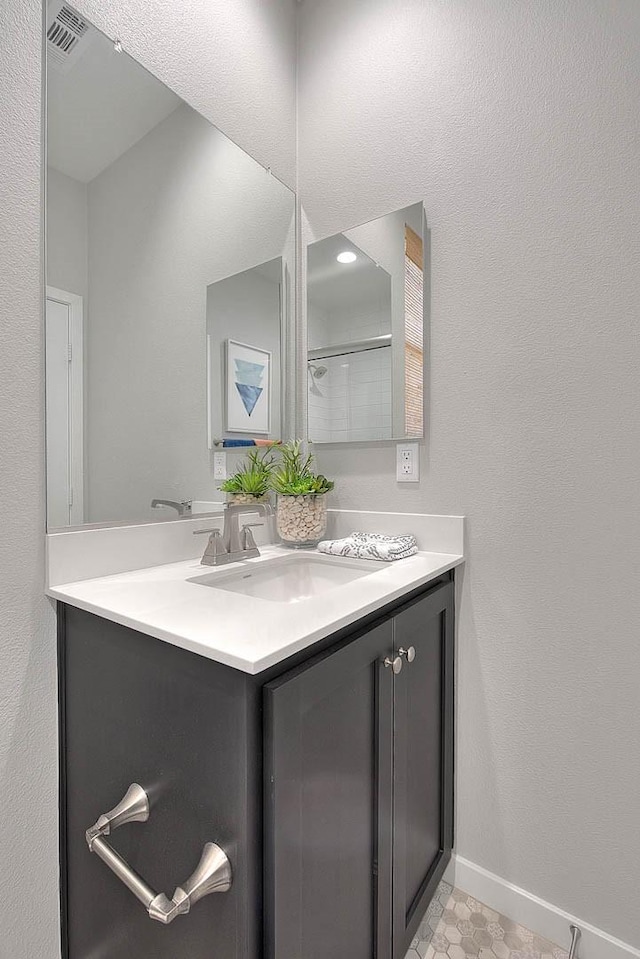 bathroom featuring visible vents, vanity, and baseboards