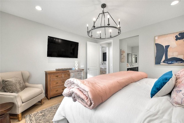 bedroom featuring an inviting chandelier, light wood-style flooring, ensuite bathroom, and recessed lighting