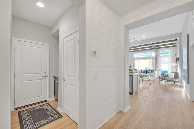 hallway featuring coffered ceiling, light hardwood / wood-style flooring, and beam ceiling