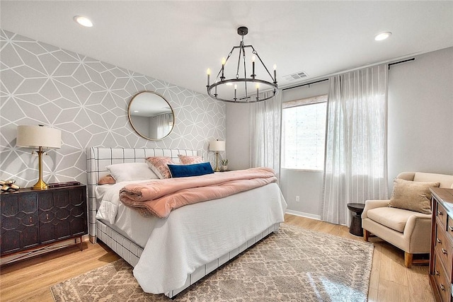 bedroom featuring a chandelier and light hardwood / wood-style floors