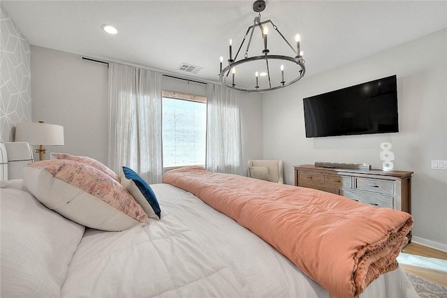 bedroom featuring light hardwood / wood-style flooring and an inviting chandelier