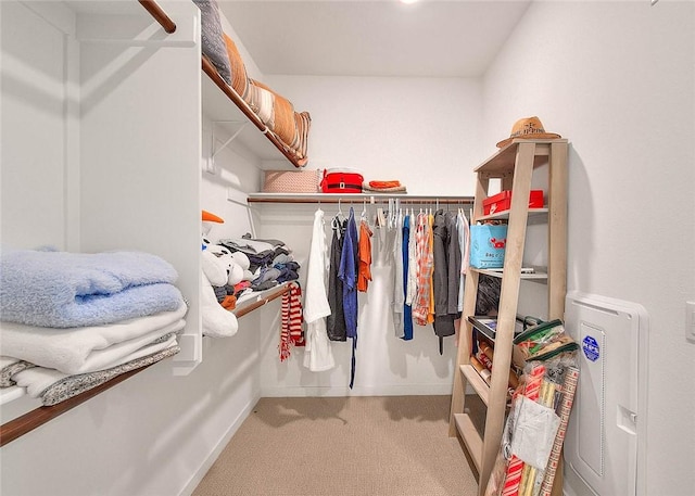 walk in closet featuring light carpet