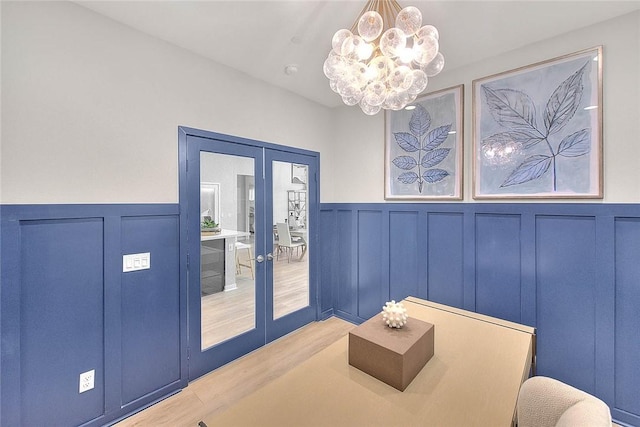 entryway with a notable chandelier, light wood-type flooring, and french doors