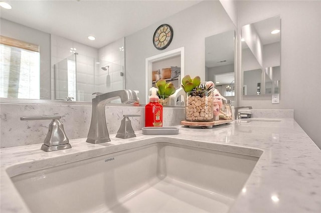 details with a stall shower, decorative backsplash, and vanity