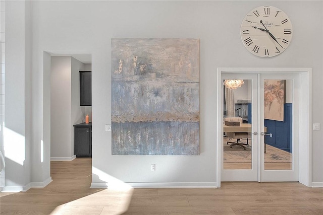 interior space with french doors, baseboards, and wood finished floors