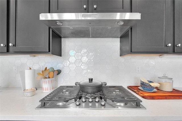 kitchen featuring stainless steel gas stovetop, backsplash, and range hood