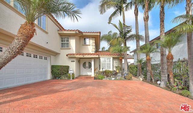 mediterranean / spanish-style home with a garage