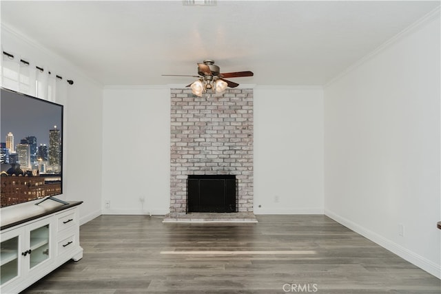 unfurnished living room featuring ceiling fan, dark hardwood / wood-style floors, ornamental molding, and a fireplace