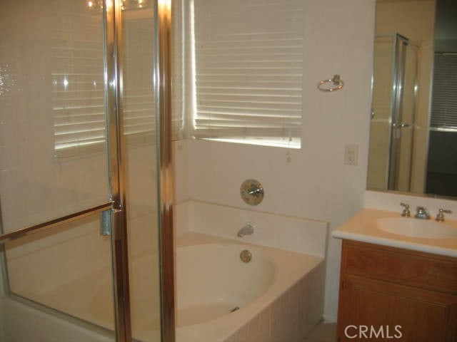 bathroom with shower with separate bathtub and vanity