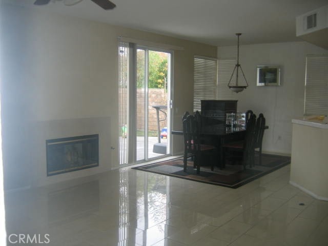 unfurnished dining area featuring ceiling fan and tile patterned floors