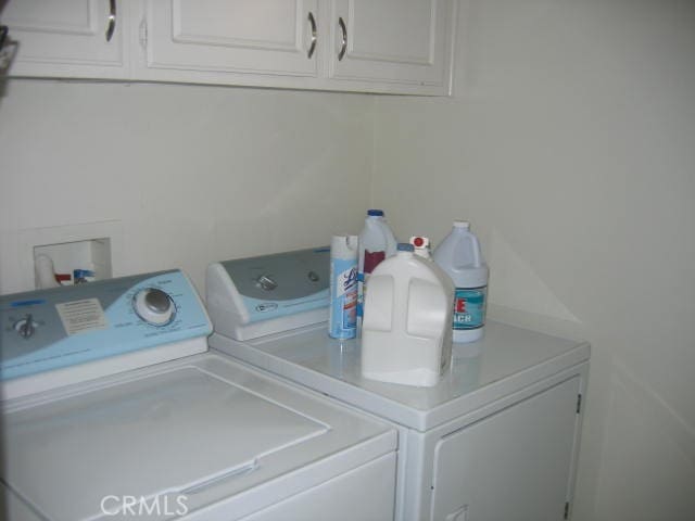 washroom with cabinets and washer and clothes dryer