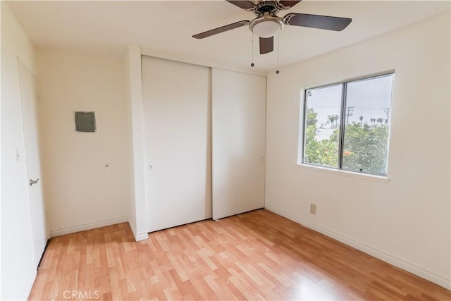 unfurnished bedroom featuring ceiling fan, a closet, and light hardwood / wood-style floors