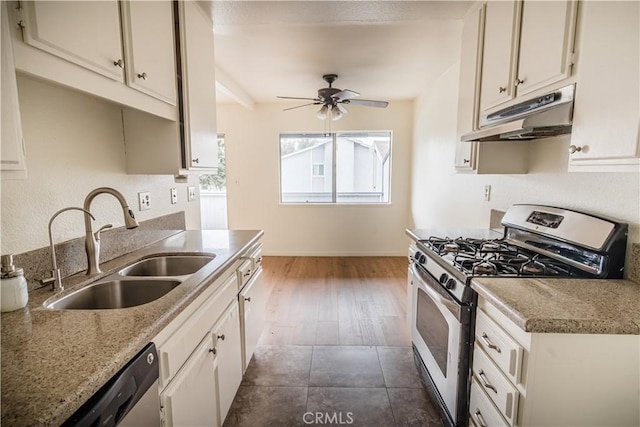 kitchen featuring ceiling fan, gas range, sink, white cabinets, and light stone counters