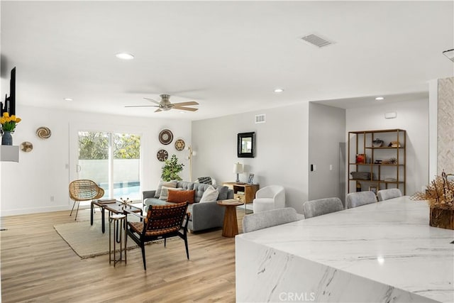 living room featuring ceiling fan and light hardwood / wood-style floors