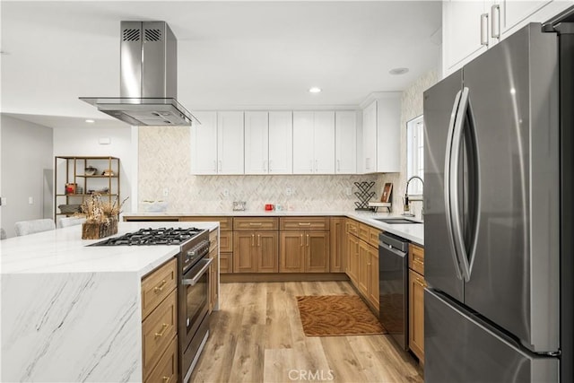 kitchen featuring white cabinets, wall chimney exhaust hood, stainless steel appliances, sink, and light wood-type flooring