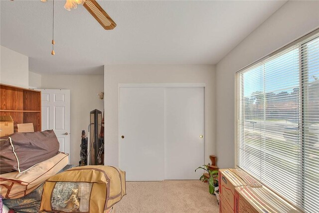 sitting room featuring ceiling fan and light carpet