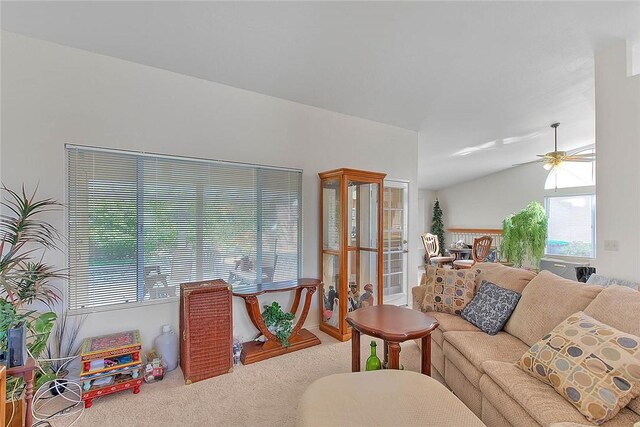 living room with ceiling fan, carpet floors, and lofted ceiling